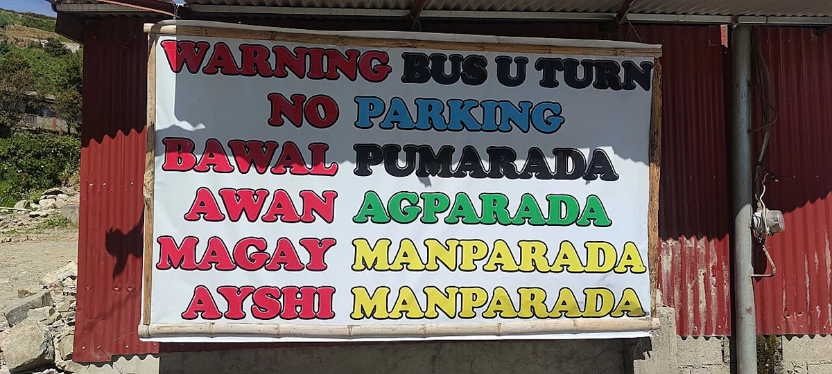 A sign that says, "Warning Bus U Turn, No Parking" with "No Parking" translated in other Philippine languages.